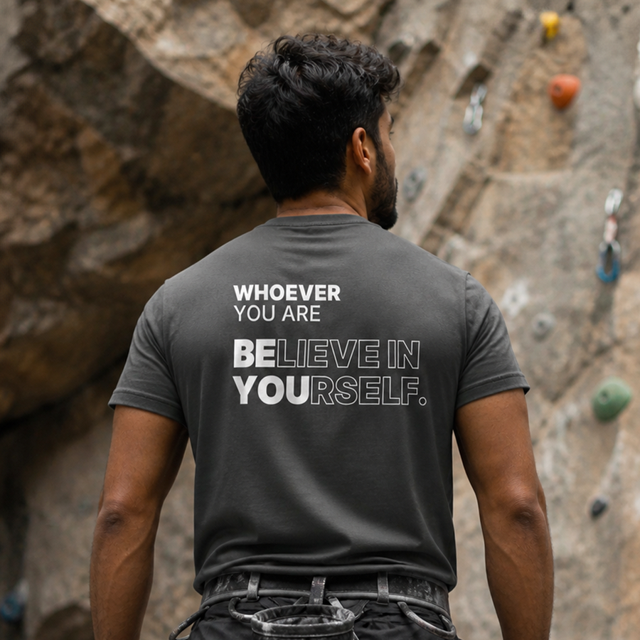 Person wearing a gray Believe in Yourself motivational t-shirt with back print at a rock climbing wall