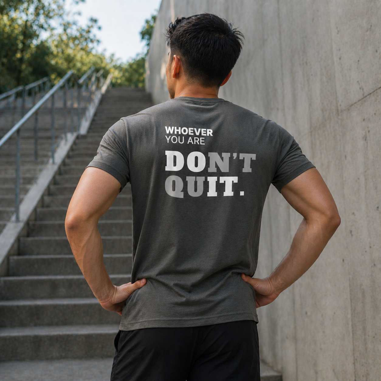 Person wearing a gray Don’t Quit motivational t-shirt outdoors with back print visible