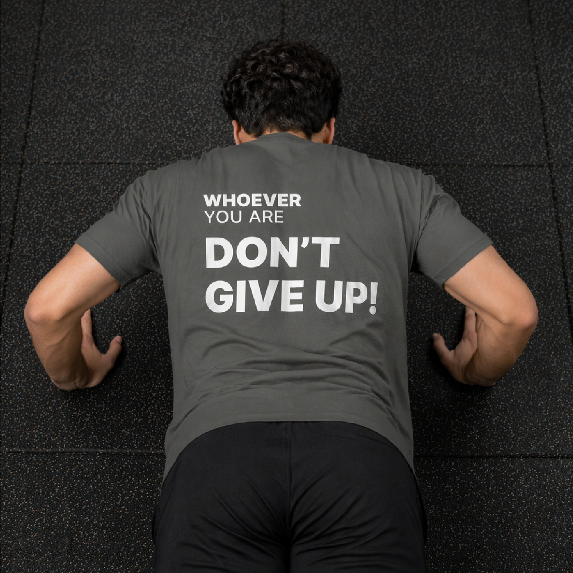 Person wearing a gray Don’t Give Up! motivational t-shirt during a workout