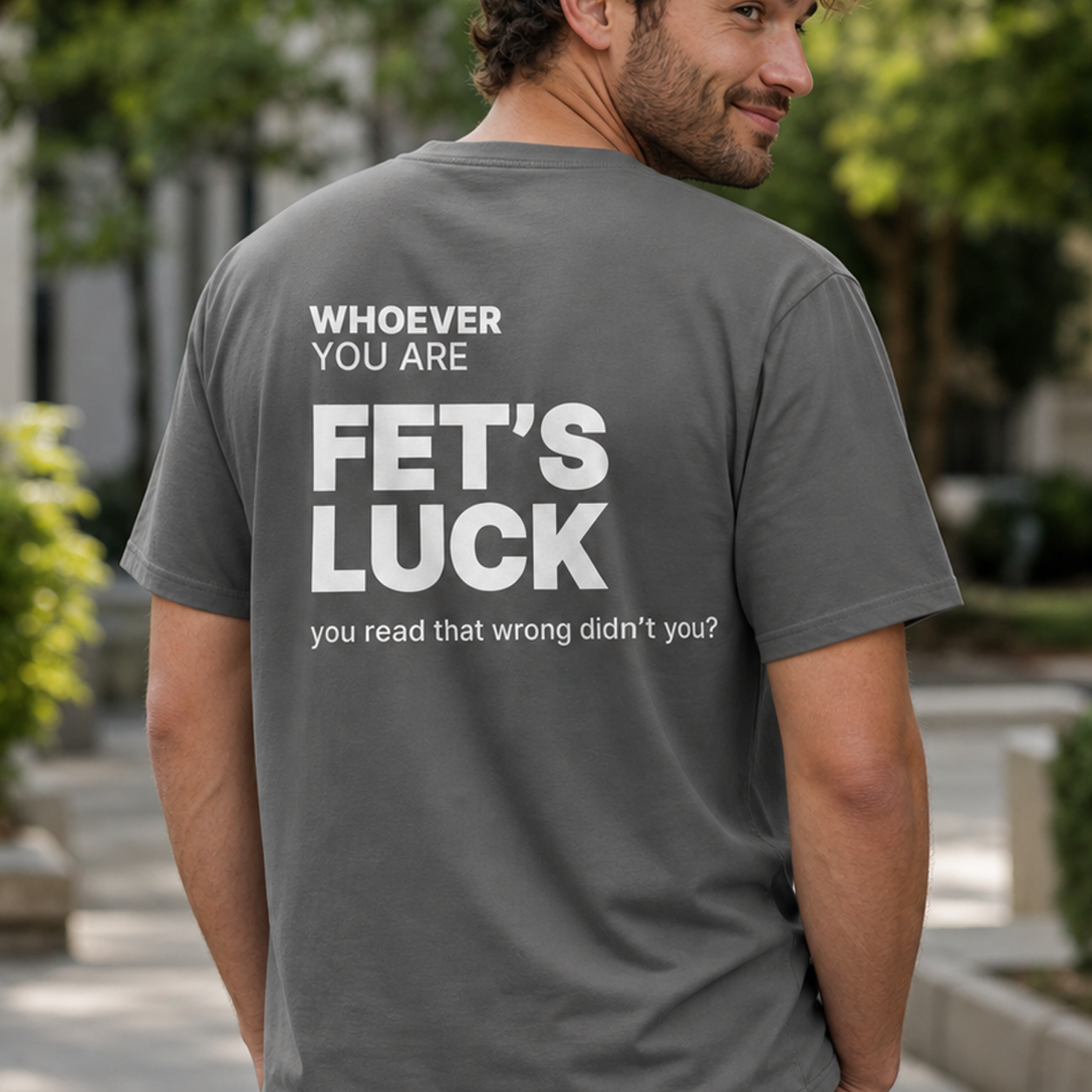 Person wearing a gray Fet’s Luck funny t-shirt with cheeky back print outdoors