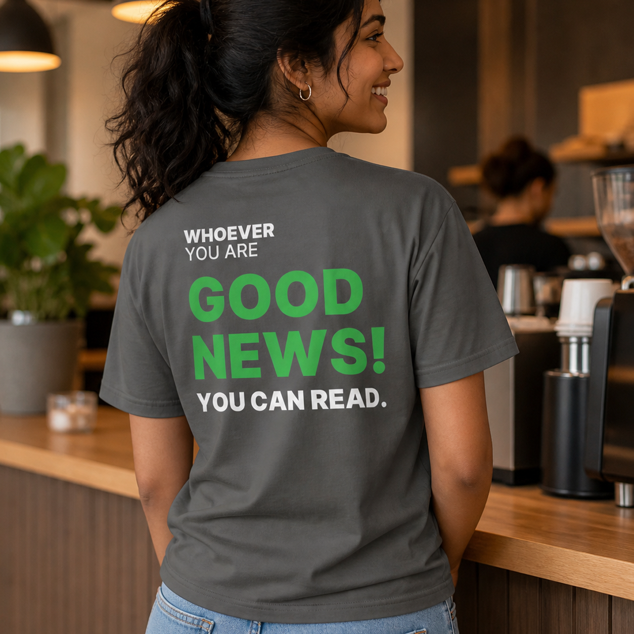 Person wearing a gray Good News! You Can Read funny t-shirt in a casual setting