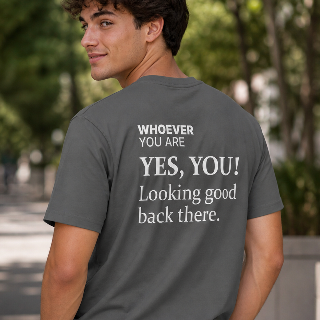 Person wearing a gray Yes, You! Looking Good Back There t-shirt outdoors with back print visible