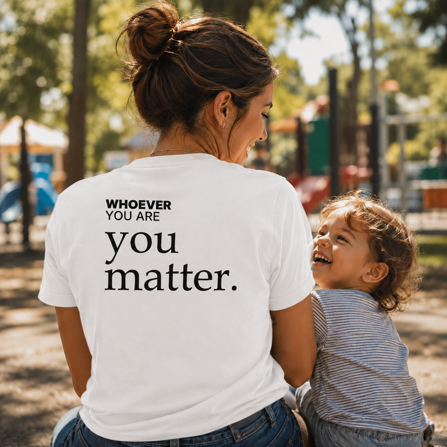 Person wearing a white You Matter kindness t-shirt with meaningful back print in a park